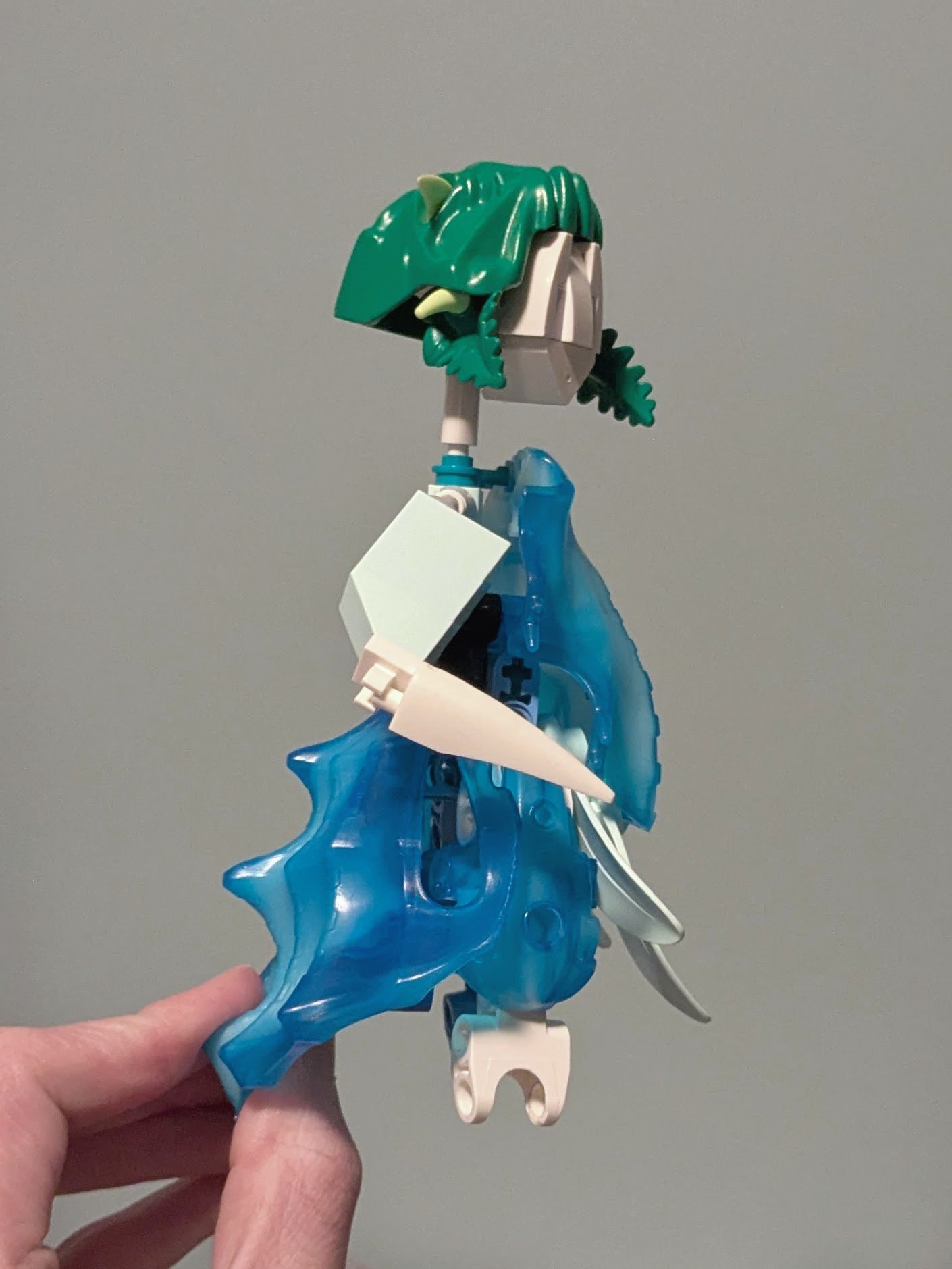 Figure’s dress from the side, one smooth element forming the bodice and a rough one forming the back of the skirt