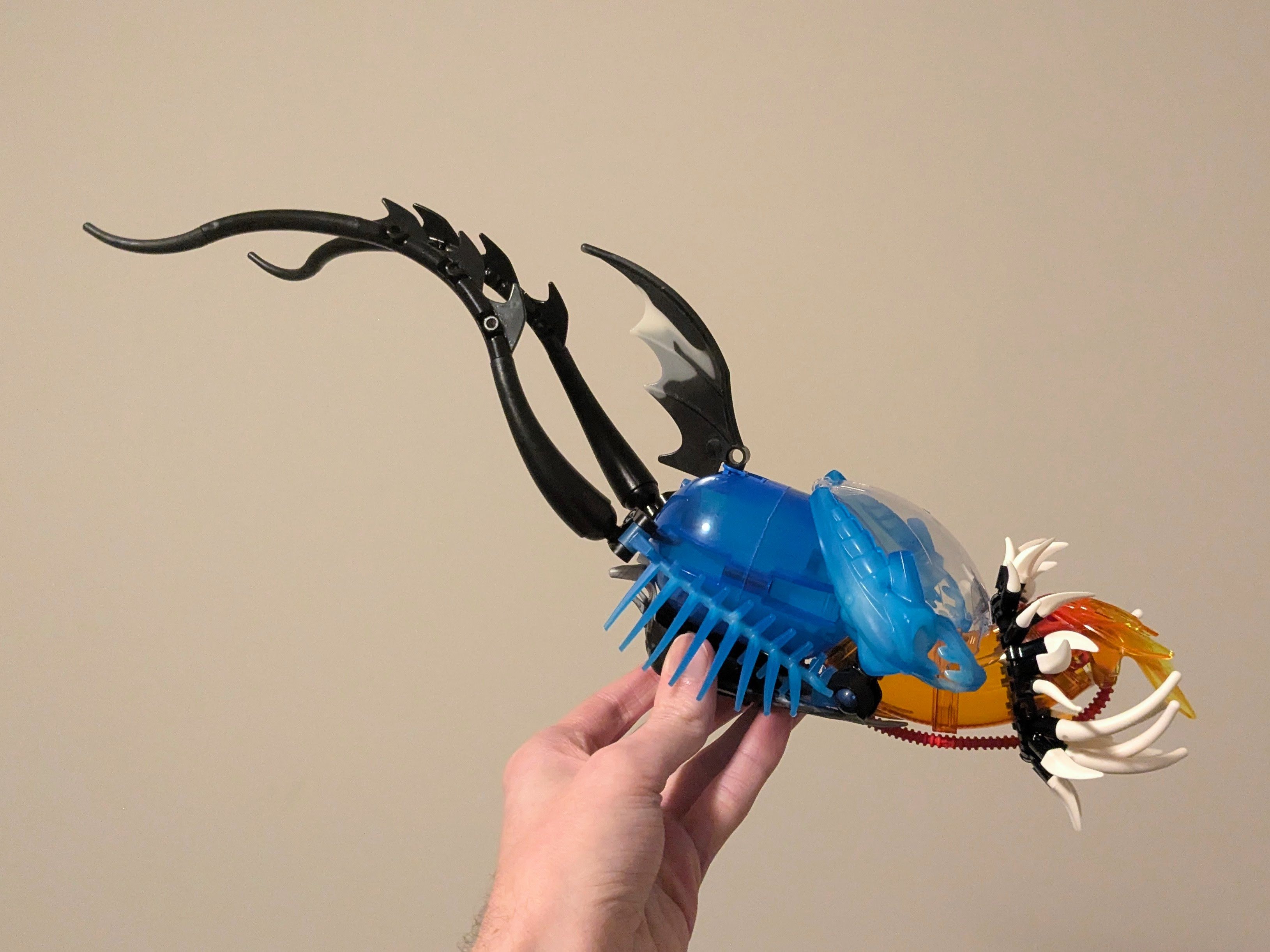 Two curving black tendrils arc from the back of the creature’s round body