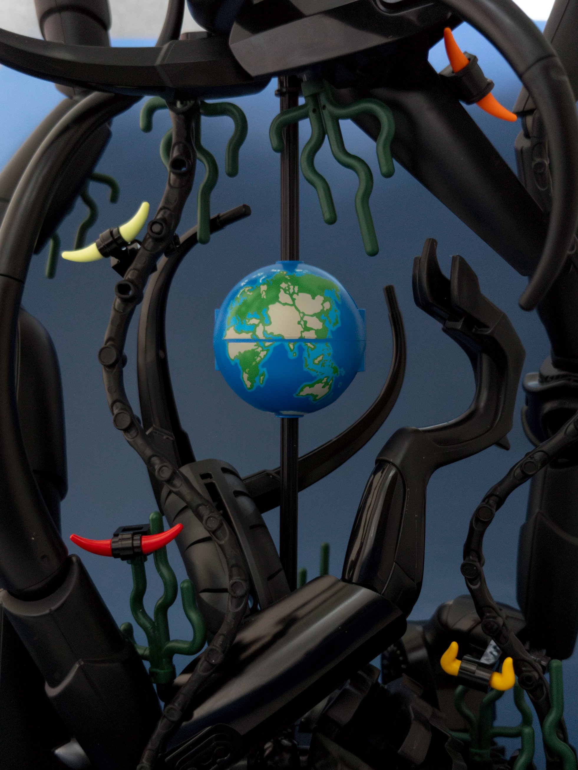 Black axle shows through the poles of the Earth; paper backdrop is cut off at the top edge